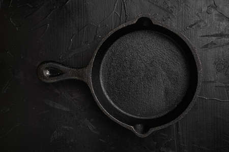 Empty frying pan set with copy space for text or food with copy space for text or food, top view flat lay, on black dark stone table backgroundの写真素材