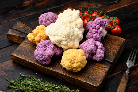 Fresh heads cleaned cauliflower set, on cutting board, on old dark wooden table backgroundの写真素材