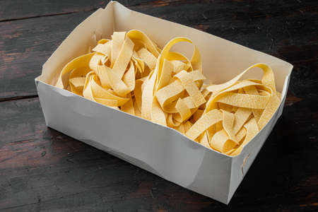 Italian pasta pappardelle set, on old dark wooden table backgroundの写真素材