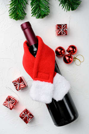 Wine bottles with Santa red hat set, on white stone table background, top view flat layの写真素材