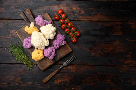 Fresh organic cauliflower cut into small pieces set, on cutting board, on old dark wooden table background, top view flat lay, with copy space for textの写真素材