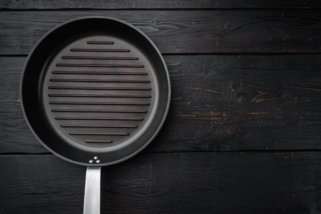 Vintage empty grill pan set with copy space for text or food with copy space for text or food, top view flat lay, on black wooden table backgroundの写真素材