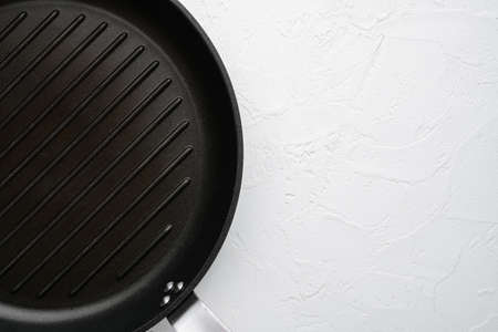 Empty grill pan set with copy space for text or food with copy space for text or food, top view flat lay, on white stone table backgroundの写真素材