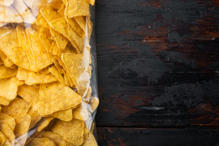Nachos, triangle traditional Mexican corn appetizer, on old wooden table, top view or flat lay with...
