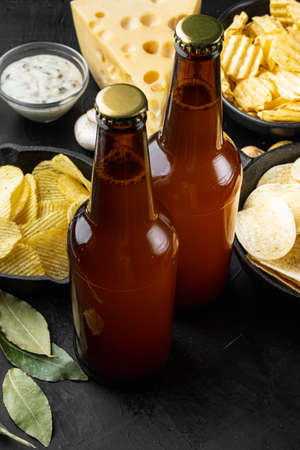 Potato chips. Beer snacks, sauce set, on black stone backgroundの写真素材