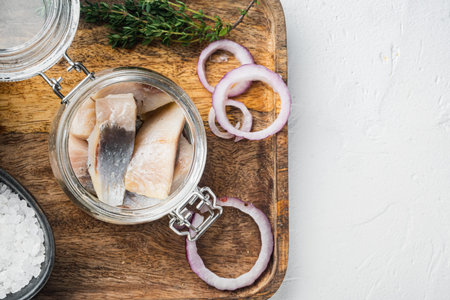 Fillet of salted Dutch herring in oil, on white background, top view flat lay with copy space for...