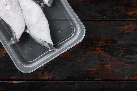 Fish fillet frozen pack set, on old dark wooden table background, top view flat lay, with copy space for textの写真素材