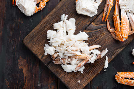 Boiled blue swimming crab claws set, on wooden cutting board, on dark wooden background, top view flat layの写真素材