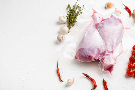 Turkey legs vacuum pack set, with copy space for text, on white stone table backgroundの写真素材