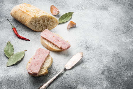 Open pork luncheon meat can with baguette set, on gray stone table background, with copy space for textの写真素材