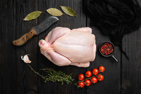 Organic raw whole chicken set, on black wooden table background, top view flat layの写真素材