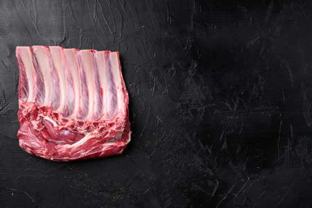 Raw fresh rack of lamb meat set, on black dark stone table background, top view flat lay, with copy space for textの写真素材
