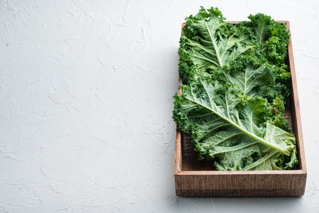 Whole leaves of Italian salad Kale set, in wooden box, on white background, with copyspace and space for textの写真素材