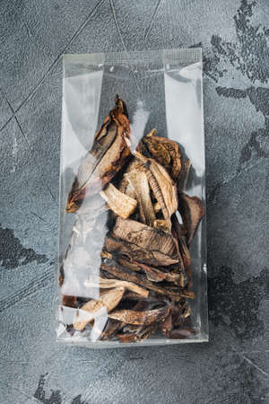 Dried mushrooms set, on gray background, in plastic pack, top view flat layの写真素材