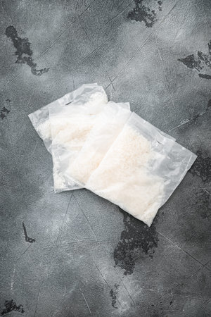 Rice basmati in portion bags set, on gray stone table background, top view flat lay, with copy space...