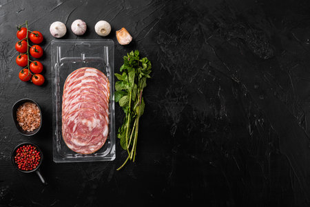 Slice of Italian ham and meat in vacuum package set, on black dark stone table background, top view flat lay, with copy space for textの写真素材