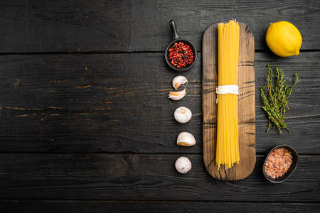 Bunch of spaghetti, raw pasta set, on black wooden table background, top view flat lay, with copy space for textの写真素材