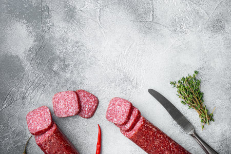 Salami with herbs and spices set, on gray stone table background, top view flat lay, with copy space...