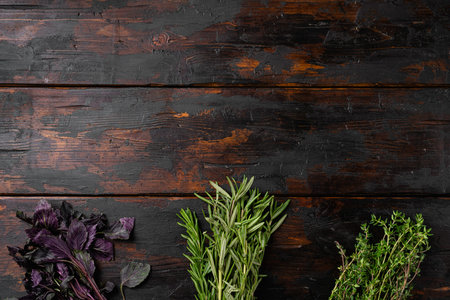 Garden fresh herbs rosemary, thyme, basil set, on old dark wooden table background, top view flat...