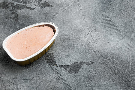 Fresh liver pate in a can set, on gray stone table background, with copy space for text