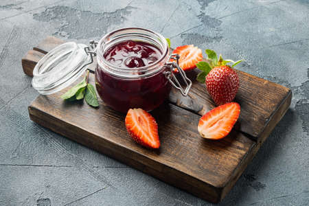 Homemade delicious strawberry jam and fresh berry, on gray backgroundの写真素材