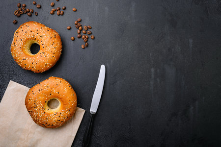 Fresh Bagels with Sesame, on black dark stone table background, top view flat lay, with copy space for textの写真素材