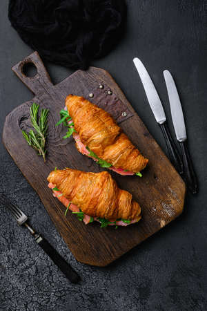 Croissant sandwich with salmon set, on black dark stone table background, top view flat layの写真素材