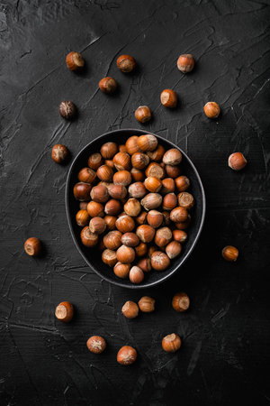 Hazelnut nut health organic brown filbert set, on black dark stone table background, top view flat...