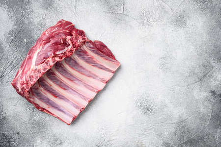 Lamb ribs cooking. Raw rack of lamb meat set, on gray stone table background, top view flat lay, with copy space for textの写真素材