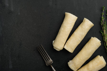 Semi finished pancakes, on black dark stone table background, top view flat lay, with copy space for...