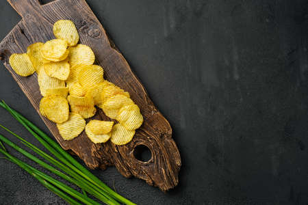 Wavy Ranch Flavored Potato Chips, on black dark stone table background, top view flat lay, with copy space for textの写真素材