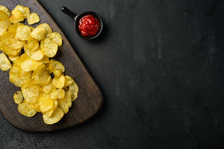 Chesapeake Bay Crab Spice Flavored Potato Chips, on black dark stone table background, top view flat lay, with copy space for textの写真素材