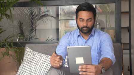 Young Indian male entrepreneur making video call using tablet for consulting about New project....