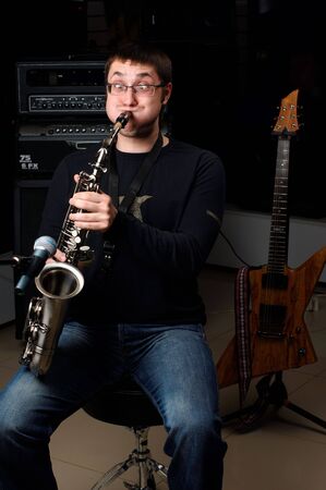 young male play in study on saxophoneの写真素材