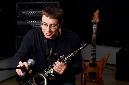 young male play in study on saxophoneの写真素材