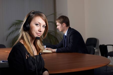 young female talk by  headset with microphone in officeの写真素材