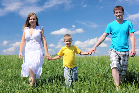 family with son in summer day on the meadowの写真素材