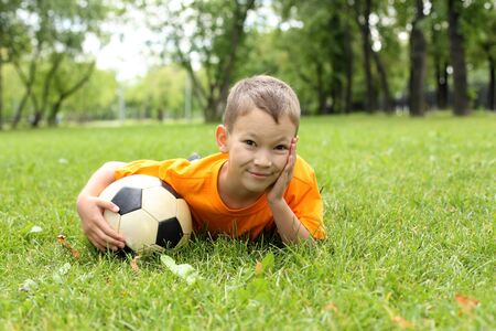 Little boy in the summer park with a ballの写真素材
