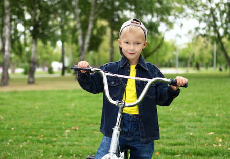 Happy smiling boy on a bicycle in the green parkの写真素材