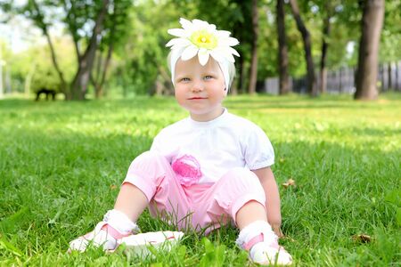 Little girl  eating strawberries in the summer parkの写真素材