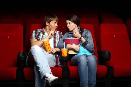 Young couple sitting in cinema and watching movieの写真素材