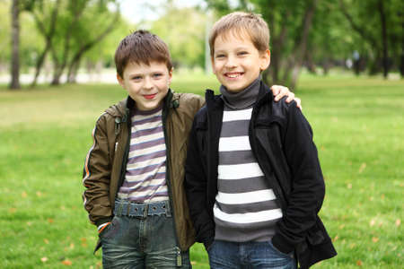 Happy smiling boy with a friend in the green parkの写真素材