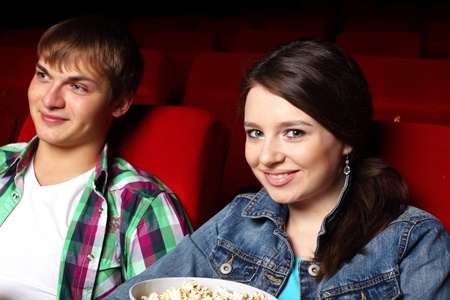 Young couple sitting in cinema and watching movieの写真素材