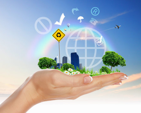 Collage with a human hand holding a green landscape