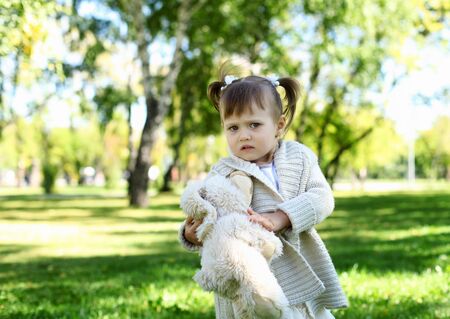 Portrait of a little girl playing in green summer parkの写真素材