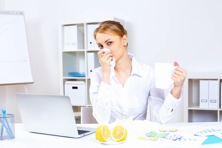 Young woman feeling unwell and sick in officeの写真素材