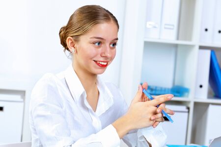 Young pretty woman in business wear working in officeの写真素材
