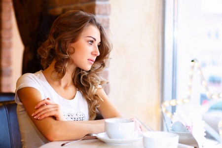 Portrait of young pretty woman sitting in restaurantの写真素材