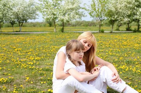 happy girl and her mother in the spring park among flowersの写真素材