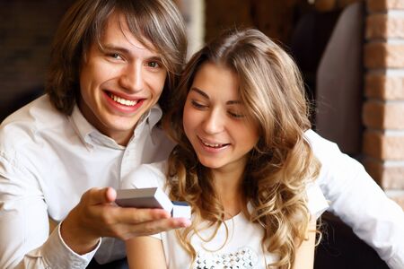 Young couple with a ring during an engagement in a restaurantの写真素材